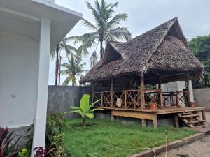 hutte avec toit de paille et palmiers dans l'établissement Mafia Island Bungalows, à Utende