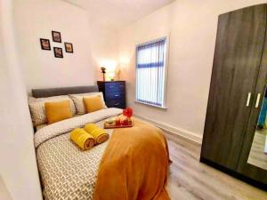 um quarto com uma cama com almofadas amarelas em Welcoming Corner Retreat em Liverpool