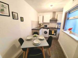 a small kitchen with a table and chairs in a room at Modest Urban Escape in Liverpool