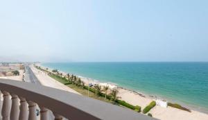 Dibba Sea View Hotel by AMA Pro في دبا: منظر على الشاطئ والمحيط من الشرفة