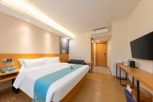 a hotel room with a large bed and a flat screen tv at Xana Lite Hotel - Guangzhou Fangcun Huadiwan Metro Station in Guangzhou