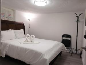 ein Schlafzimmer mit einem weißen Bett mit einer Blume darauf in der Unterkunft Tidy Private Rooms with Full Kitchen in Toronto