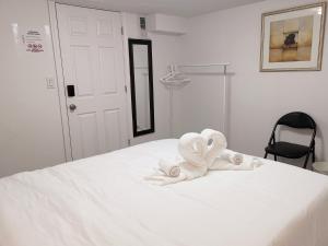 uma cama branca com toalhas por cima em Tidy Private Rooms with Full Kitchen em Toronto