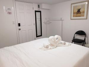 een wit bed met handdoeken erop bij Tidy Private Rooms with Full Kitchen in Toronto +4 foto's