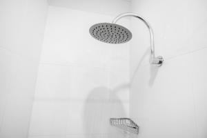 een douche met een douchekop in een badkamer bij Central Motel Mooloolaba in Mooloolaba