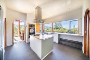 een keuken met een wastafel en grote ramen bij Eclectic Luxurious 70s Mansion in Wellington