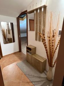 un couloir avec une table et un vase avec une plante dans l'établissement Sicilia Bedda Apartment, à Messina