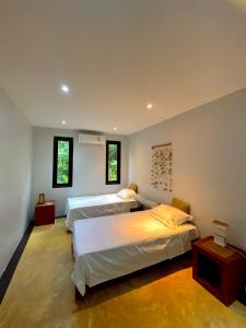 a bedroom with two beds and two windows at 泰暖WarmThai（karon） in Karon Beach