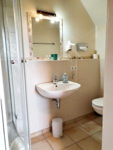 La salle de bains est pourvue d'un lavabo et de toilettes. dans l'établissement Alt Enginger Mühle, à Paderborn