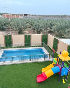 a swimming pool with a slide and a playground at Traveler Rooms 2 in Al Madinah