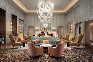a lobby with a couch and chairs and a chandelier at The St. Regis Venice in Venice