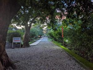 een grindweg met bomen en een bord erop bij VistaBerge in Bagac