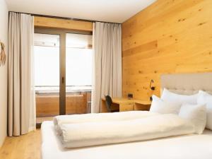 - une chambre avec 2 lits et un bureau dans l'établissement My Heimat 1495 Arlberg, à Schröcken