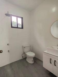 a bathroom with a toilet and a sink and a mirror at Chateau d' sentier in Davao City