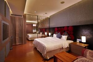 薇風情汽車旅館 - 台南館 في Liujia: غرفة نوم بسرير كبير ومرآة