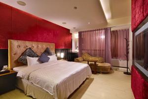 sypialnia z dużym łóżkiem i czerwoną ścianą w obiekcie 薇風情汽車旅館 - 台南館 w mieście Liujia
