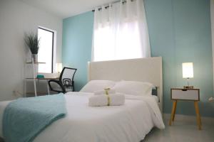 um quarto com uma cama branca, uma secretária e uma janela em STAR HOME-wynwood/airport/miami em Miami