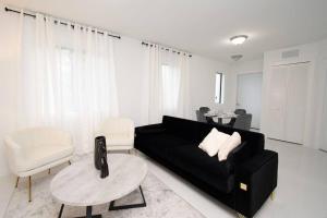 uma sala de estar com um sofá preto e uma mesa em STAR HOME-wynwood/airport/miami em Miami