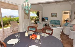 a dining room with a table and a living room at Saint Barth Villa 7 in Pointe Milou
