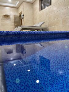 a large swimming pool with a blue tiled floor at Palace Hotel Tashkent in Tashkent