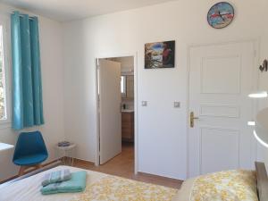 1 dormitorio con 1 cama y 1 silla azul en Chambres d'hôtes dans propriété rurale en Béziers
