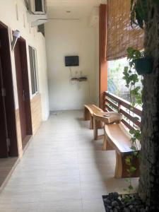 a hallway with benches and a television in a building at Rumah Tourist in Banyuwangi