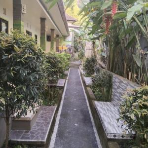 a hallway of a building with benches and plants at green view downtown in Ubud