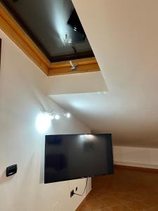 a flat screen tv in a room with a ceiling at Sicilia Bedda Apartment in Messina