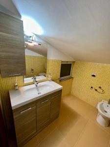 a bathroom with a sink and a toilet at Sicilia Bedda Apartment in Messina