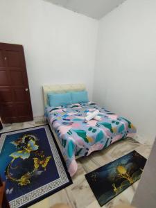 een slaapkamer met een bed en twee tapijten op de vloer bij Yong's Stay Sri Manjung in Seri Manjung