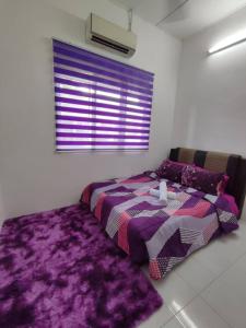 een slaapkamer met een bed en een paars tapijt bij Yong's Stay Sri Manjung in Seri Manjung
