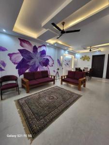 a living room with two couches and a rug at BnBBuddy Athulyam 3 BHK Homestay, Shalimar Bagh in New Delhi