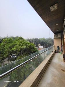 a balcony of a building with a view of trees at BnBBuddy Athulyam 3 BHK Homestay, Shalimar Bagh in New Delhi