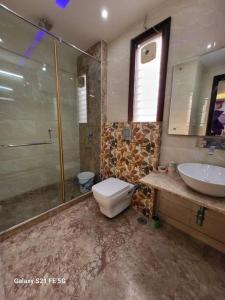 a bathroom with a toilet and a sink at BnBBuddy Athulyam 3 BHK Homestay, Shalimar Bagh in New Delhi