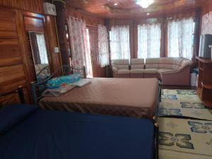 a bedroom with a bed and a couch in a room at Duangmanee home stay 