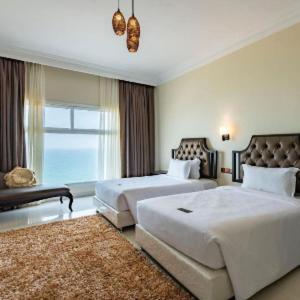 um quarto de hotel com duas camas e uma janela em Dibba Sea View Hotel by AMA Pro em Dibba Al-Baya