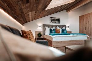 een slaapkamer met een bed en een stoel bij Tanners Chalet Apartments in Altenmarkt im Pongau