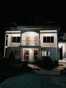 a white house with a balcony at night at Hotel Sonali in Lataguri