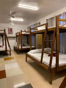 a room with three bunk beds in a room at Aquaholik Traveler's Lodge in El Nido