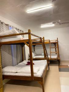 a room with three bunk beds in a room at Aquaholik Traveler's Lodge in El Nido