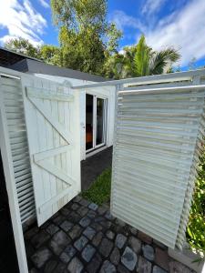 eine weiße Garage mit einem Tor und einer Einfahrt in der Unterkunft Charmant Studio avec jardin in Saint-Denis
