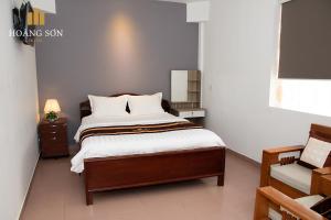 a bedroom with a bed with white sheets at Hoàng Sơn Hotel in Ho Chi Minh City