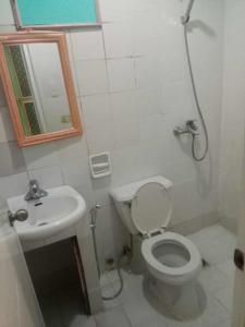 a bathroom with a toilet and a sink and a mirror at WJV INN CABANCALAN in Mandaue City