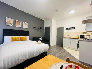 a bedroom with a large bed and a kitchen at Urban and stylish Central Studio Apartment in Liverpool with high speed free wifi in Liverpool