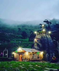 a small building with lights on top of a hill at Bajwal Home-Stay & Guest-House in Sari