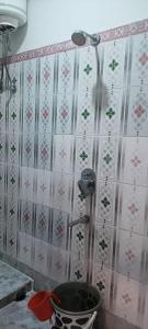 a shower in a bathroom with pink and white wallpaper at Hotel Sonali in Lataguri