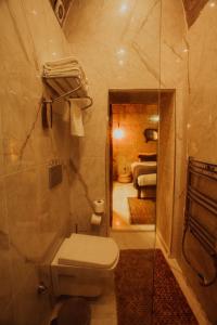 a bathroom with a toilet and a shower and a bedroom at Rox Cappadocia in Uchisar