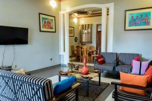 a living room with two couches and a tv at Nyumbani Cottages Kicukiro in Kigali