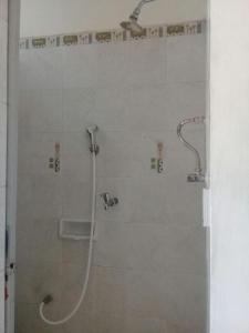 a shower with a shower head in a bathroom at Rumah Tourist in Banyuwangi