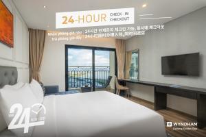 a hotel room with a bed and a tv at Wyndham Danang Golden Bay in Da Nang